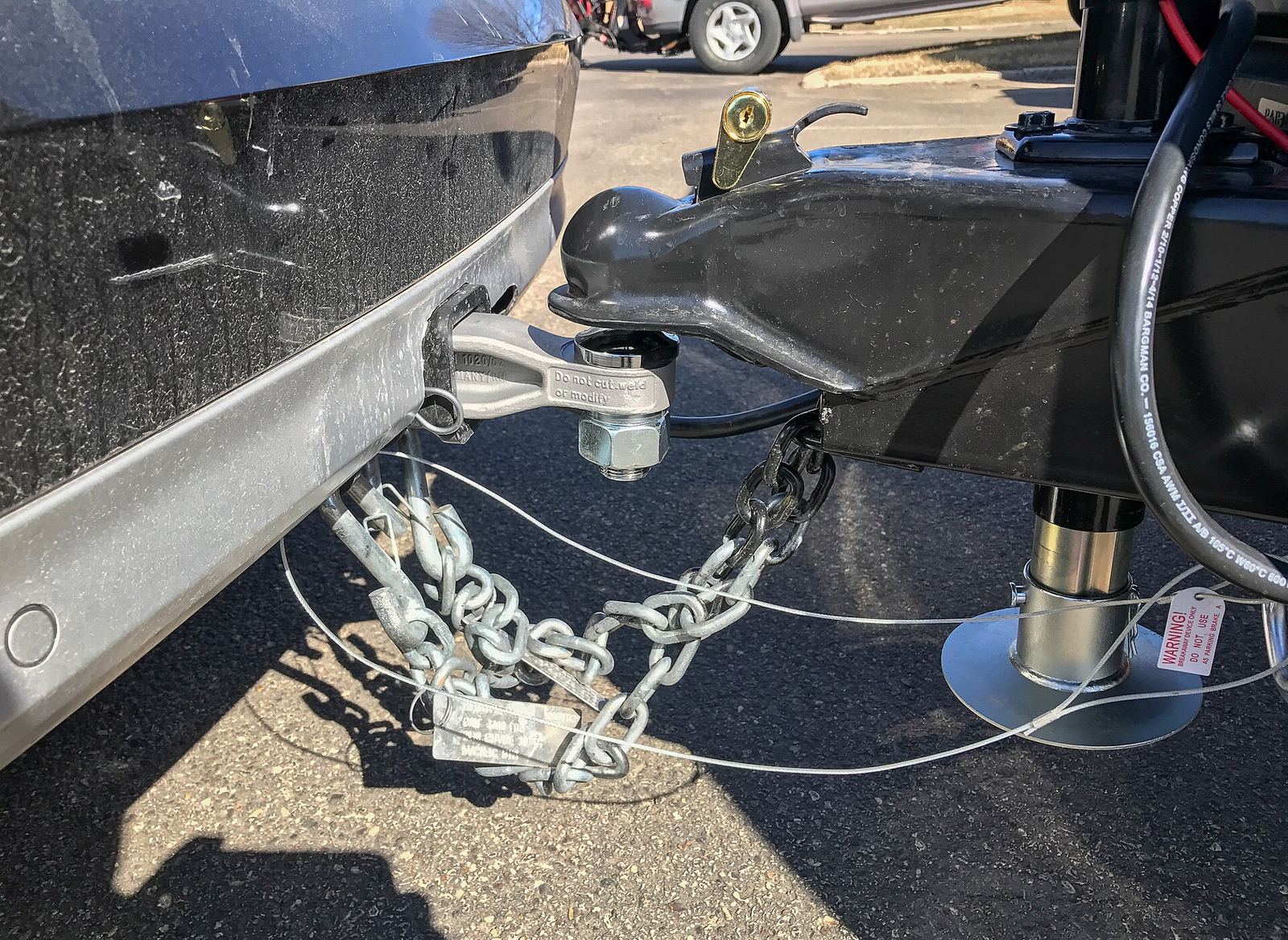 A trailer coupled to a tow ball, with its safety chains attached